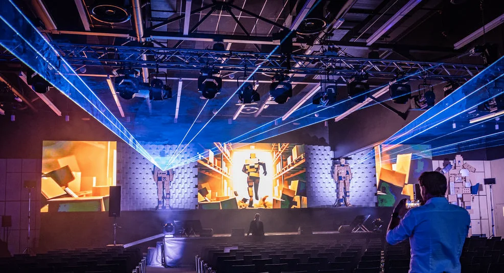 Technologická scénografie s LED obrazovkami, lasery a prostorovou instalací